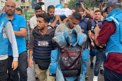 Un periodista sujeta un chaleco antibalas manchado de sangre que pertenecía al reportero palestino Mohammed Soboh, quien murió junto con otros dos compañeros cuando un misil israelí alcanzó un edificio donde estaban informando en Gaza, el día 10. 